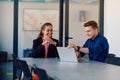 A business leader in a suit conversing with her worker in the IT industry about new business projects and existing