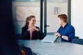 A business leader in a suit conversing with her worker in the IT industry about new business projects and existing