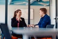 A business leader in a suit conversing with her worker in the IT industry about new business projects and existing