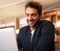 Business at leisure. a handsome young man sitting with a laptop in a cafe. Royalty Free Stock Photo