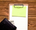 Business and lending concept. On a wooden table is an empty sheet next to a purse with money. Copy space. Royalty Free Stock Photo