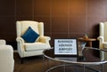 The Business Lounge Airport service time sign is placed on a modern round tempered glass table Royalty Free Stock Photo