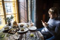 Contemporary young man in elegant restaurant using cell phone Royalty Free Stock Photo