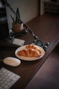 Small cup of coffee and croissants on office desk. Royalty Free Stock Photo