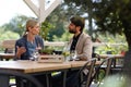 Business lunch for two managers, discussing new business project. Couple sitting outdoors on terrace restaurant, having Royalty Free Stock Photo