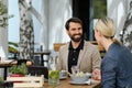 Business lunch for two managers, discussing new business project. Couple sitting outdoors on terrace restaurant, having Royalty Free Stock Photo