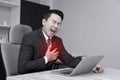 Business man asian suffering from pain in his chest or heart disease on office desk