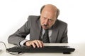 Business man with bald head on his 60s working stressed and frustrated at office computer laptop desk looking tired Royalty Free Stock Photo