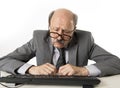 Business man with bald head on his 60s working stressed and frustrated at office computer laptop desk looking tired Royalty Free Stock Photo