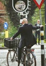 Business man on a bicycle in front of crossroad at city s Hertogenbosch in netherlands