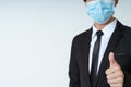 Business man in black business suit wearing medical protective mask showing thumbs up in business and organization with white Royalty Free Stock Photo