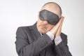 Business man in blindfold for sleeping with arms raised for rest on a white background