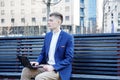 Business man. A man with a book and a laptop. The guy speaks through the phone on the street. The guy in the glasses makes notes i Royalty Free Stock Photo