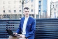 Business man. A man with a book and a laptop. The guy speaks through the phone on the street. The guy in the glasses makes notes i Royalty Free Stock Photo