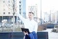 Business man. A man with a book and a laptop. The guy speaks through the phone on the street. The guy in the glasses makes notes i Royalty Free Stock Photo