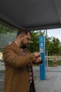 A business man at a bus stop looks at his watch. Close-up. Royalty Free Stock Photo