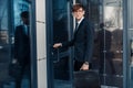 Business man businessman, enters the office building, opens the door Royalty Free Stock Photo