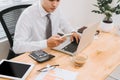 Business man busy working on laptop computer and using mobile smart phone in modern office, close up. Work process concept Royalty Free Stock Photo