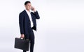 Business man carrying briefcase and talking on mobile phone Royalty Free Stock Photo