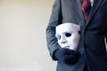 Business man carrying white mask to his body indicating Business fraud and faking business partnership Royalty Free Stock Photo