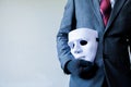 Business man carrying white mask to his body indicating Business fraud and faking business partnership