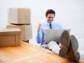 Business man, celebrate and logistics in office with fist pump, laptop and online for shipping boxes. Male person Royalty Free Stock Photo