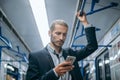 business man checking his email correspondence in the subway.