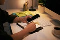 A business man is checking phone and writing in his notebook while sitting at his working table Royalty Free Stock Photo