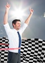 Business man cheering at finish line against sky and sun and checkered flag Royalty Free Stock Photo