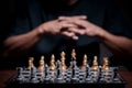 Business man with clapped hands planning a strategy with chess figures on chessboard Royalty Free Stock Photo