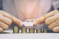 Business man and close up hand holding model of toy car white on over a lot money of stacked coins - insurance, loan and buying ca Royalty Free Stock Photo