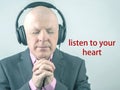 Business man with closed eyes listens to sound through headphones. Metaphor listen to your heart Royalty Free Stock Photo