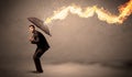 Business man defending himself from a fire arrow with an umbrella Royalty Free Stock Photo