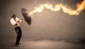 Business man defending himself from a fire arrow with an umbrella Royalty Free Stock Photo