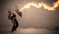 Business man defending himself from a fire arrow with an umbrella Royalty Free Stock Photo