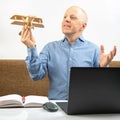 Business man dreams of his achievement. Business dream concept. A man holds a wooden airplane model in his hands Royalty Free Stock Photo