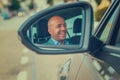 Business man driver in his car looking to the road side view mirror Royalty Free Stock Photo