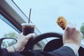 Business man driving car while eating fried chicken and cold soft drink