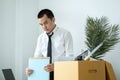 Business man employee packing document and picking up personal belongings into brown cardboard box