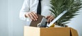 Business man employee packing notebook and picking up personal belongings into brown cardboard box Royalty Free Stock Photo