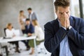 Business man feeling exhausted and stand at his working place in office Royalty Free Stock Photo