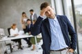 Business man feeling exhausted and stand at his working place in office Royalty Free Stock Photo