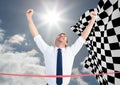 Business man at finish line against sky and checkered flag Royalty Free Stock Photo