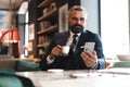 Business man in formal clothing using mobile phone. Serious businessman using smartphone at work Royalty Free Stock Photo