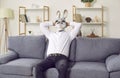 Business man in funny rabbit mask enjoying weekend, sitting on sofa and relaxing