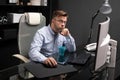 Business man with glasses working in the office at computer table and drinking coffee from bright Cup Royalty Free Stock Photo