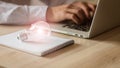 A business man in a gray shirt sitting in front of a laptop and a lamp next to him is thinking and thinking about the technology o Royalty Free Stock Photo