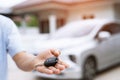 Business man hand holding car keys front with new car