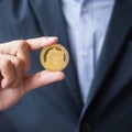 Business man hand holding gold Dogecoin cryptocurrency, Crypto is Digital Money within the blockchain network, is exchanged using