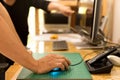 Business man hand holding mouse with colleague looking at computer hand pointing at screen